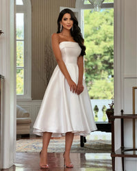 a woman in a white dress posing for a picture