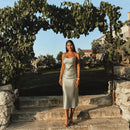 a woman in a white dress is standing on some steps