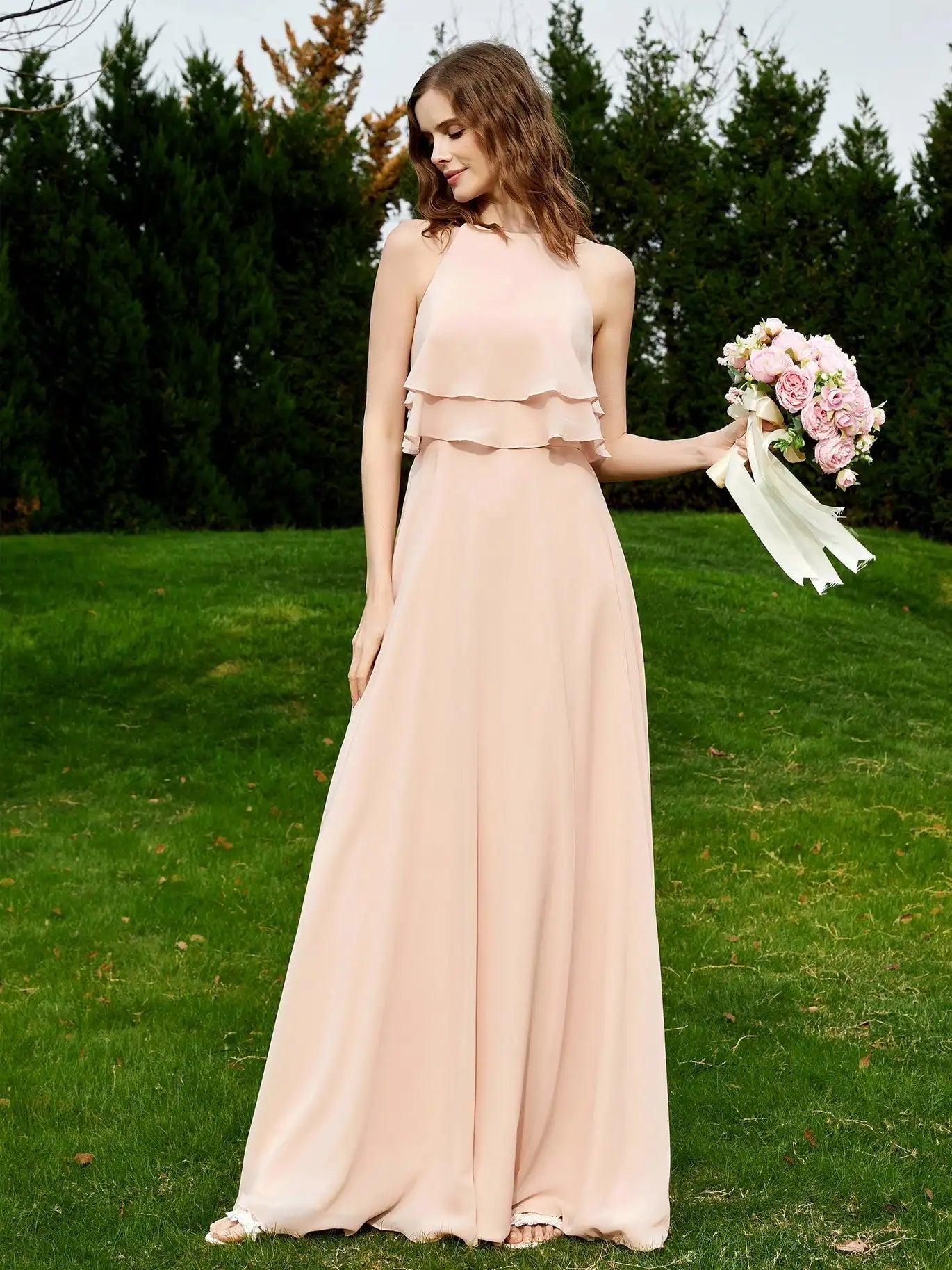 a woman in a long dress holding a bouquet of flowers