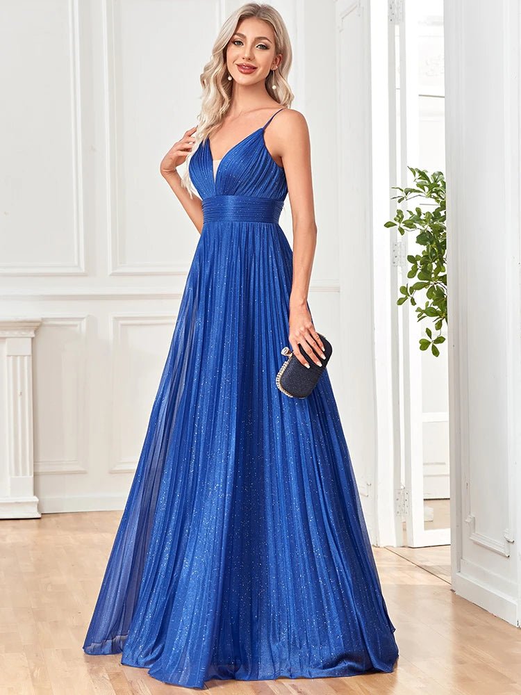 A-line spaghetti strap prom gown in navy blue with flowing draped design.