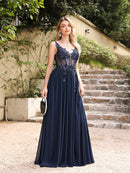 a woman in a long blue dress standing in front of stairs