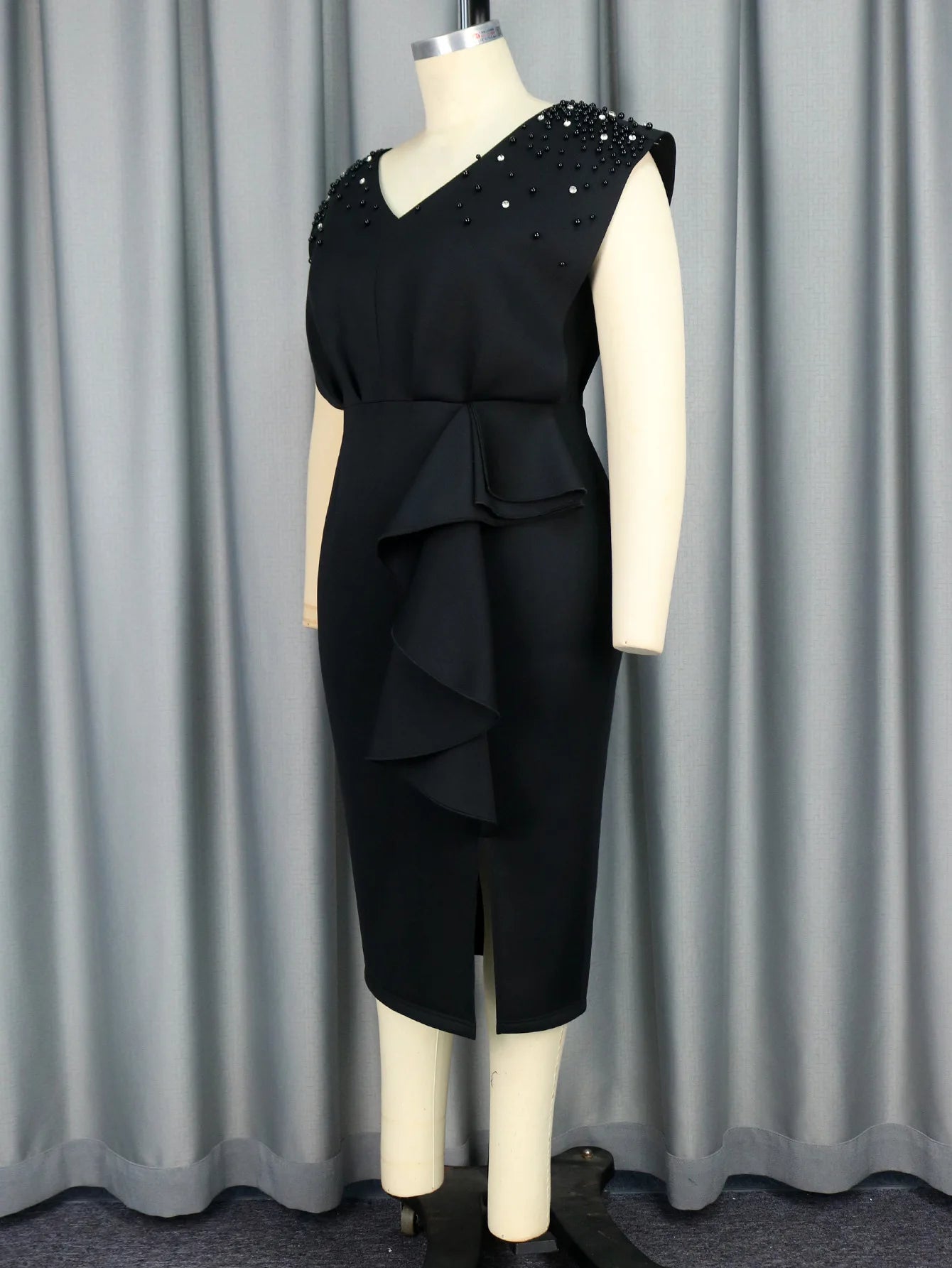 a mannequin dressed in a black dress with pearls