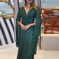 a woman in a green dress posing for a picture