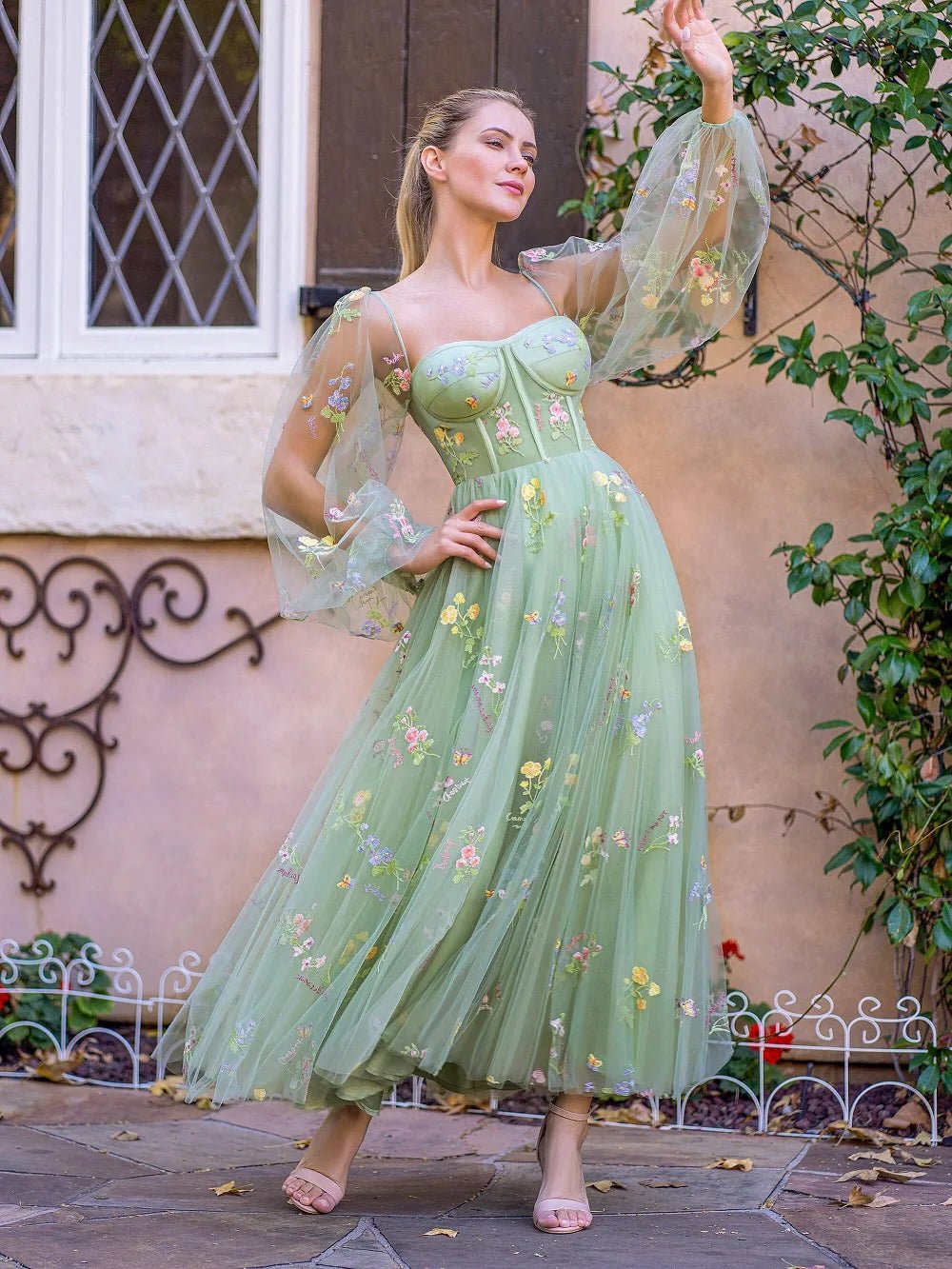 a woman in a green dress standing in front of a building