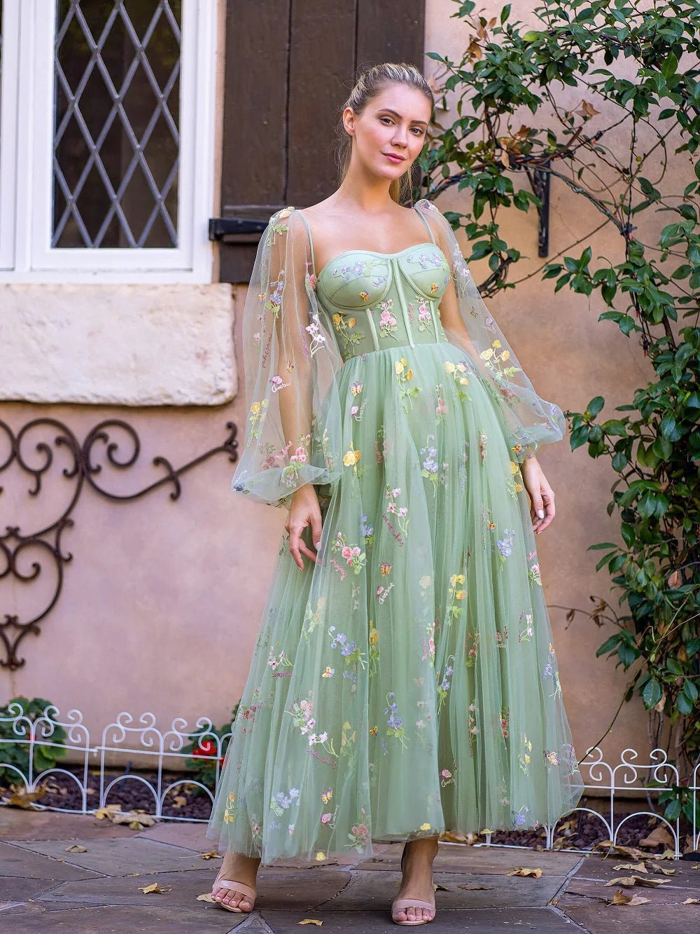 a woman in a green dress standing in front of a building