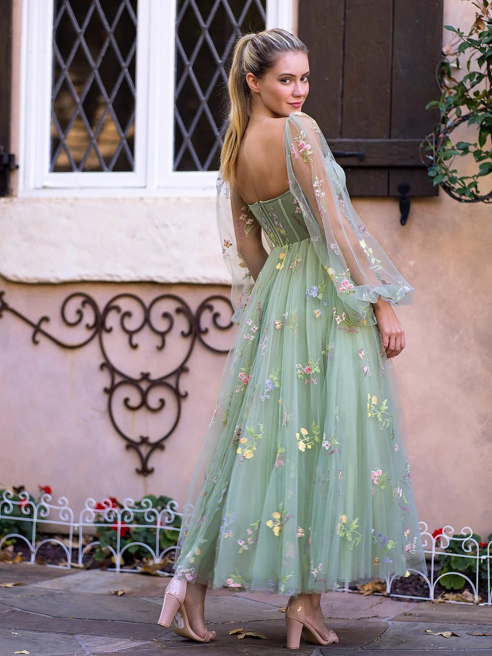 a woman wearing a green dress with flowers on it