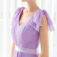 a woman wearing a purple dress with ruffles on the shoulders