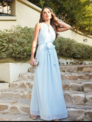 a woman in a blue dress standing on some steps