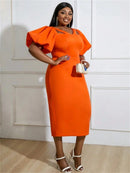 a woman in an orange dress posing for a picture