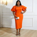 a woman in an orange dress posing for a picture