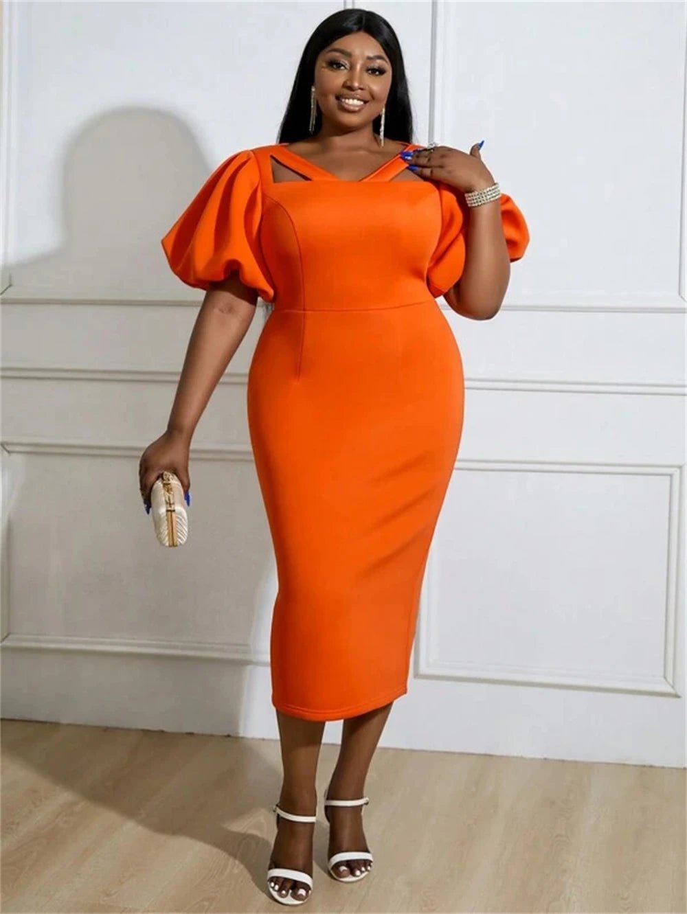 a woman in an orange dress posing for a picture