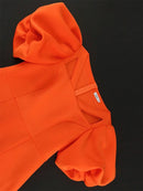 a close up of an orange hoodie on a black background