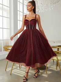 a woman in a red dress standing in front of a chandelier