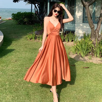 a woman in an orange dress standing in the grass