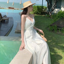 a woman sitting on a ledge next to a pool