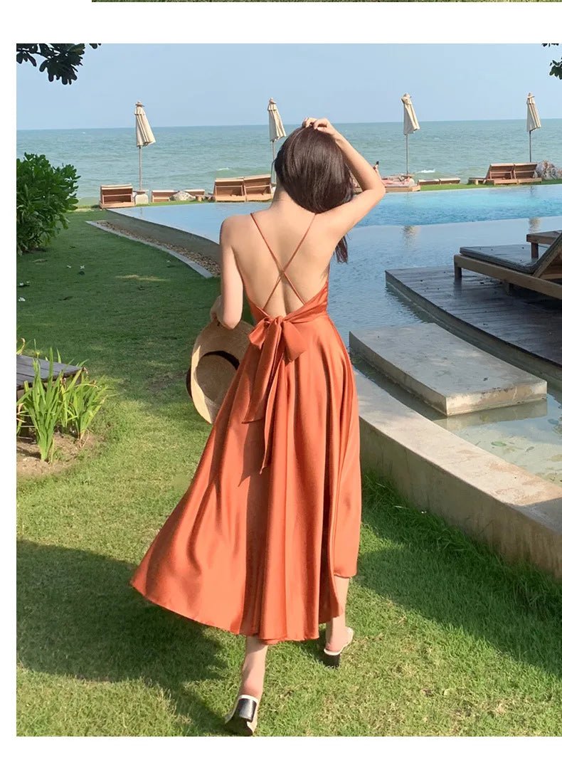 a woman in an orange dress standing in front of a pool