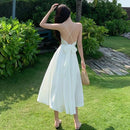 a woman in a white dress standing in the grass