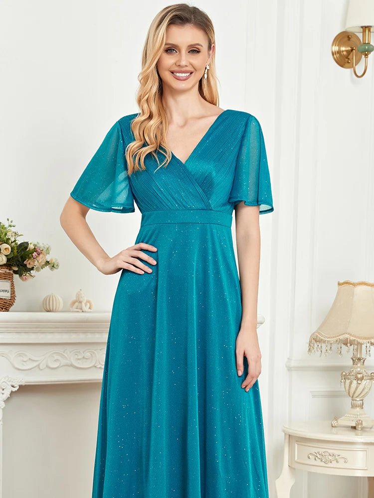 Elegant turquoise short sleeve evening gown, size M, with a flowing design.