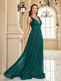 a woman in a long green dress posing for a picture