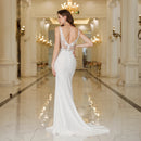 a woman in a white dress standing in a hallway