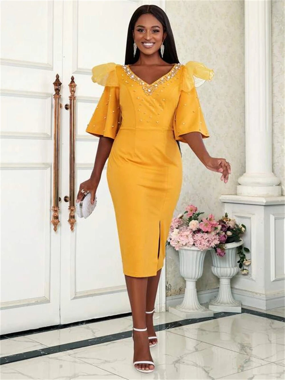 a woman in a yellow dress standing in front of a door