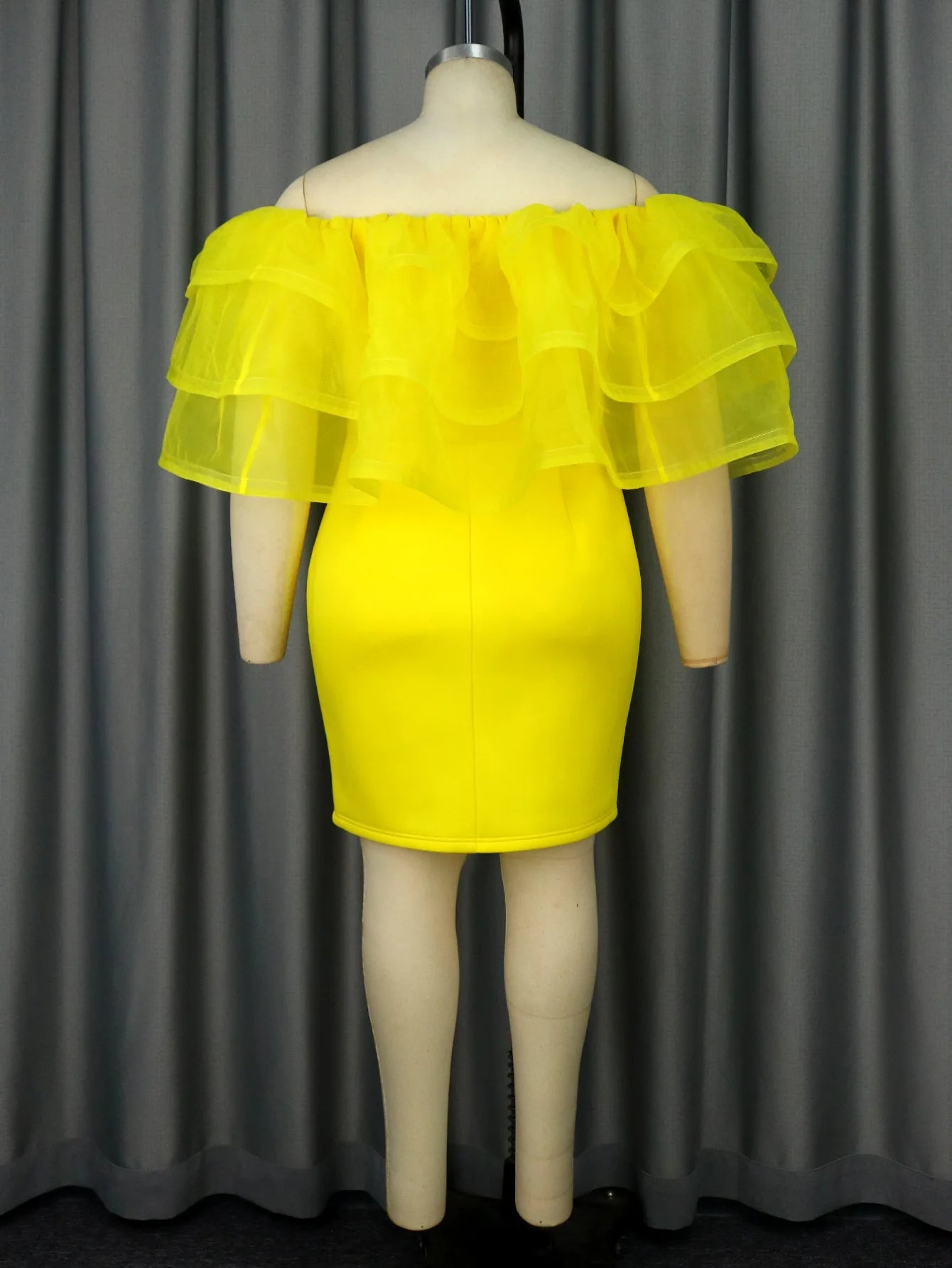 a mannequin wearing a yellow dress with ruffles