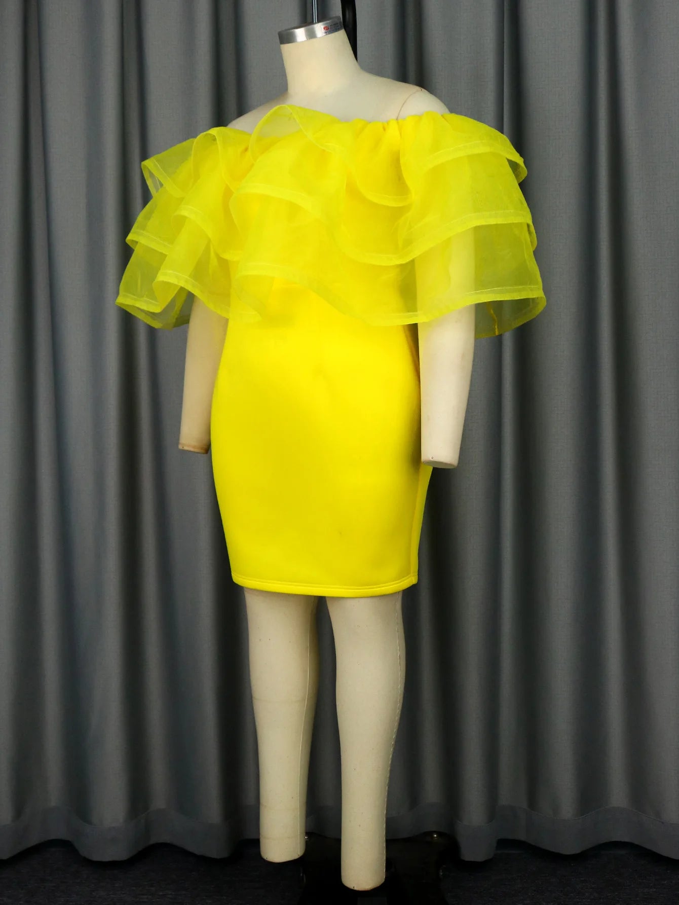 a mannequin wearing a yellow dress with ruffles